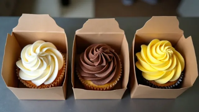 Three open kraft boxes, each holding one frosted cupcake in vanilla, chocolate or lemon, seen from above on a counter